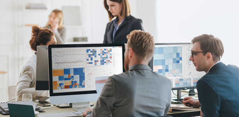 Zwei Männer betrachten Datenanalytik auf Desktop-Computern