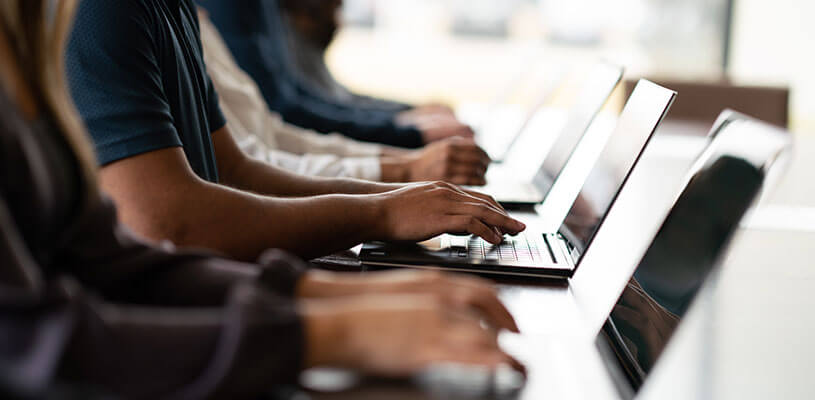 Hände von Leuten, die am Laptop arbeiten